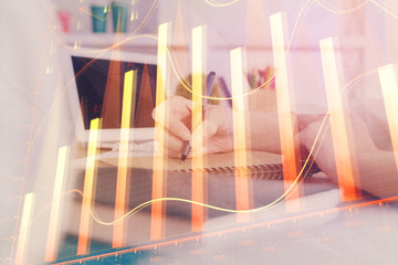 Financial graph displayed on woman's hand taking notes background. Concept of research. Double...