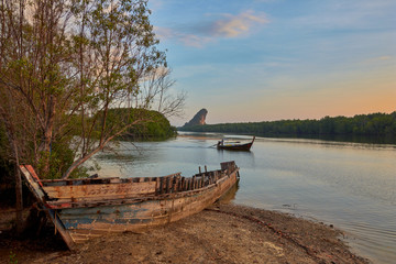 a wrecked boat on a bank of Krabi River.