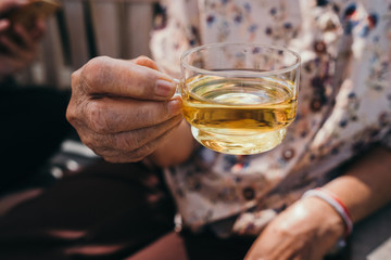 Cropped Hand Of Senior Women Holding Glass Tea