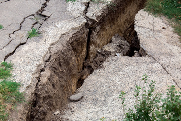 cracks in the asphalt road due to landslides after a geological natural disaster.