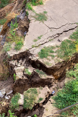Consequences of a natural cataclysm of a landslide of soil, crack asphalt paving, close up nobody.