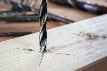 Drill work. Making hole into the wood with drill bit.