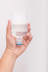 A bottle of saline in the hands of men on white background