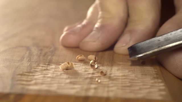 woodcarver carves a chisel notch in the board