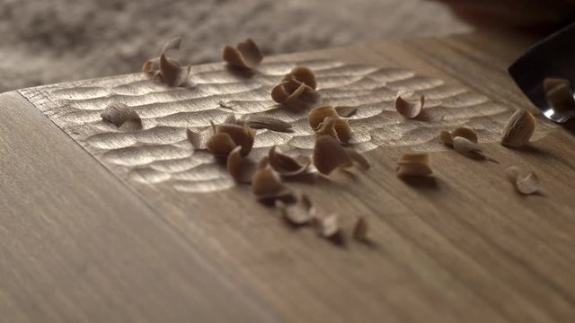 woodcarver carves a chisel notch in the board