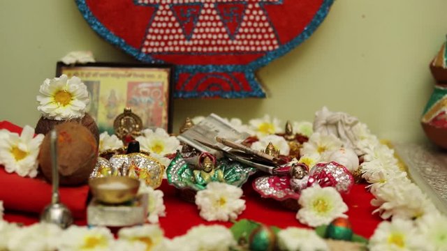 Indian wedding ceremony : Lord sculpture and  decorative coper kalash with green leaf and coconut 