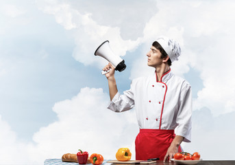 Young chef standing with megaphone in hand