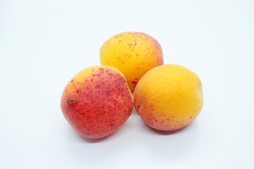 Tasty ripe beautiful apricots located on a white background