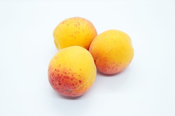 Tasty ripe beautiful apricots located on a white background