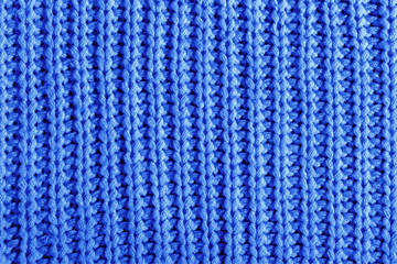 Color 2020 classic blue. Dark blue texture of a large knit sweater. Knitted scarf background, winter cozy textile background