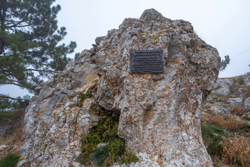 A rock on Ai-Petri with a memorial sign in honor of the caver Alexander Nikishchenko.
