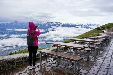Fototapeta na wymiar Young travelers taking photo of View of Innsbruck from Seegrube Mountain. Tirol, Austria.
