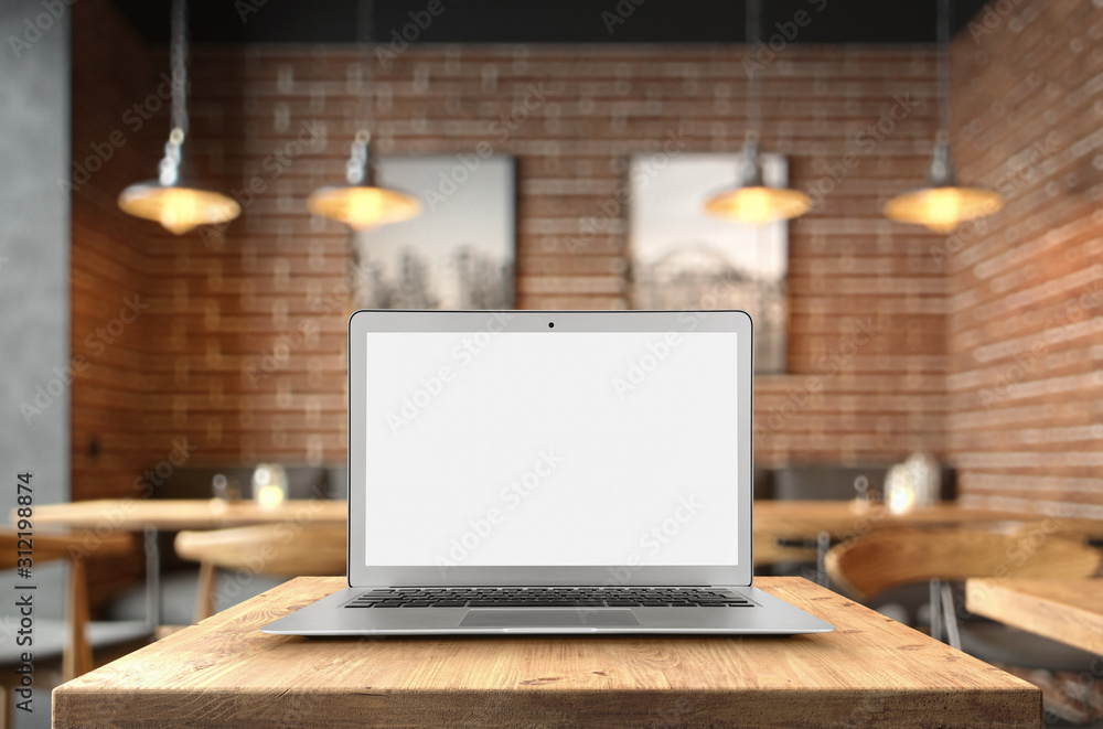 Aufkleber blank laptop on the coffee table over defocused background with copy space and clipping path for the