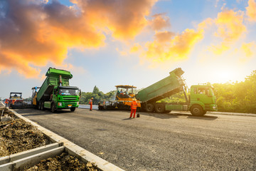 Construction site is laying new asphalt road pavement,road construction workers and road...