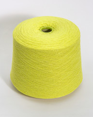 Green bobbin of yarn on a white background.Textile reel on isolated white background.