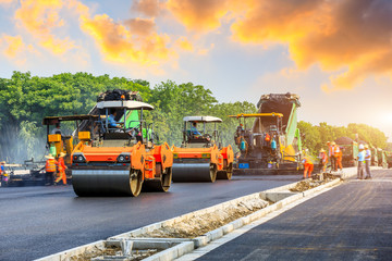 Construction site is laying new asphalt road pavement,road construction workers and road...