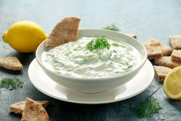 Tzatziki dip sauce with greek yogurt, garlic, dill and cucumber in white bowl