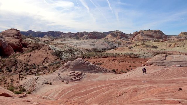 4K. Touristic people taking pictures on top of the popular Fire Wave Trail. Taking a break from walking. Young Caucasian walking in Valley of Fire State Park, Nevada.
