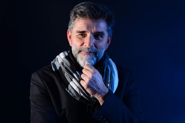 Fototapeta premium Portret przystojny mężczyzna z uśmiechem. Brodaty starszy mężczyzna patrząc na kamery z poważnym wyrazem twarzy z bliska portret głowy i ramion