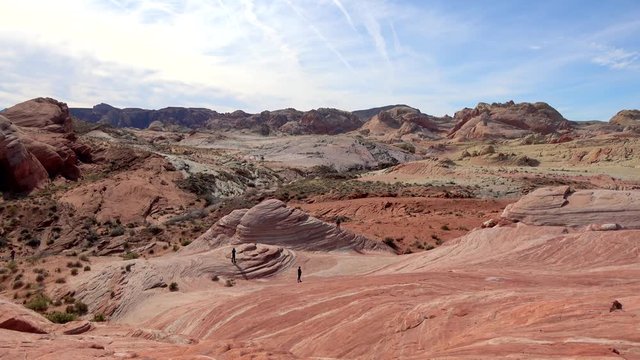 4K. Touristic people taking pictures on top of the popular Fire Wave Trail. Taking a break from walking. Young Caucasian walking in Valley of Fire State Park, Nevada.