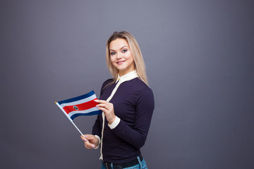 Immigration and the study of foreign languages, concept. A young smiling woman with a costa rica flag in her hand.