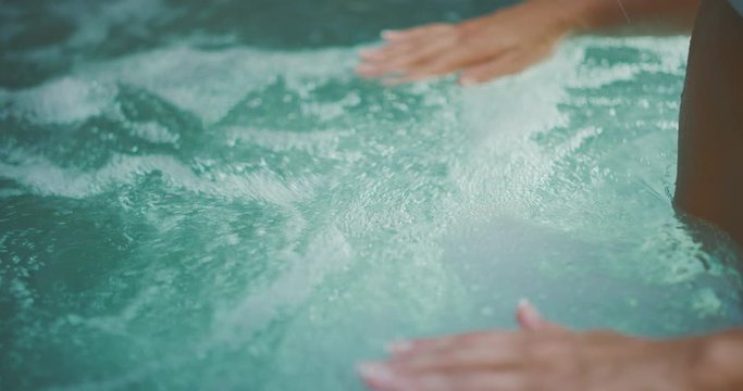 Close up of a woman's hands in a hot tub, spa wellness and relaxation concept