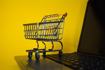 End of online sales. Online shopping, shopping cart on laptop keyboard.