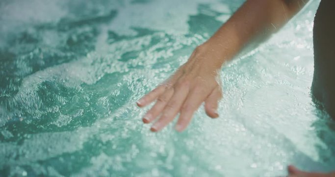 Close up of a woman's hands in a hot tub, spa wellness and relaxation concept