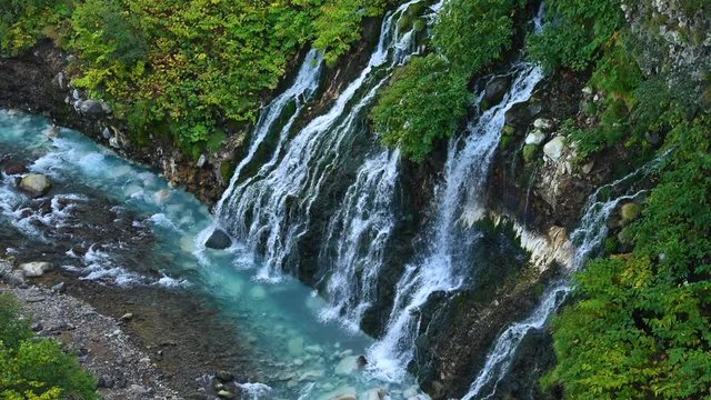 Aerial view of beautiful Shirahige Waterfalls tumbling down into Biei River in Biei, Hokkaido, Japan