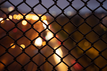 Fototapeta premium Night traffic in central stockholm with light trails behind a fence