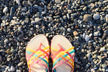 summer women's shoes on sea pebbles. space for text