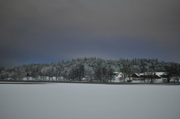 A frozen winter lake with houses on other side