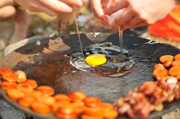 single egg on a pan in a campsite