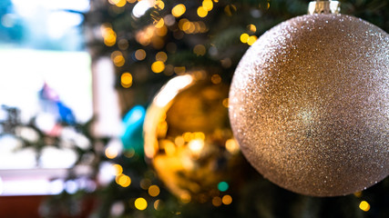 Gold Bauballs hanging from a Christmas tree