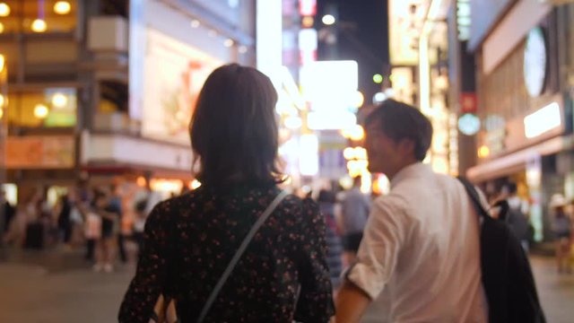  Handsom Japanese man Osaka lights background looking into camera