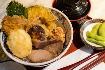 Japanese dish, Tendon or Mixed Tempura is consist of pork, egg and vegetables that have been battered and deep-fried topped on Gohan or Japanese rice served with pickled vegetable