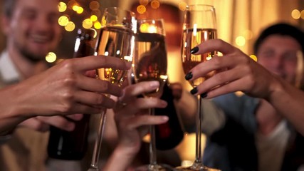 Young people are celebrating something in cafe. They are clinking glasses with beer and cocktails, drinking and chatting. Modern celebration in bar concept. - Powered by Adobe