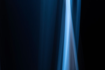 A close up macro photo of a vertical wisp of blue smoke on a black background that makes an abstract artistic retro background
