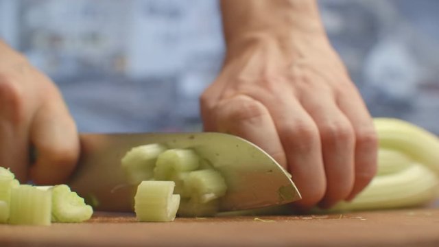 Close-up of cut celery on a board in the kitchen with a knife