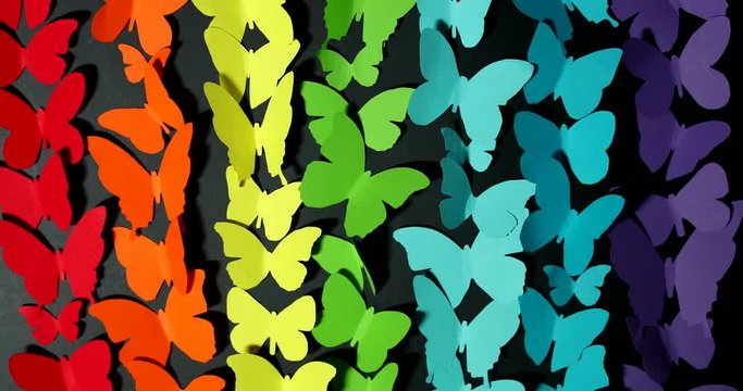 Stop motion motion of paper butterflies on a dark background.