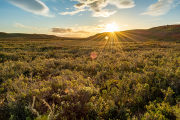 sol saliendo entre las sierras, iluminando la llanuras de la patagonia Argentina 
