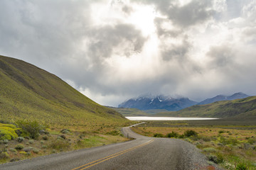 paisaje de carretera con diraccion a laguna con un fondo a las montañas del parque Torres del Paine