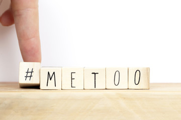 Me Too hashtag on wood cubes , anti sexual harassment social media campaign background