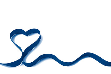 Isolated bright classic blue satin ribbon in the shape of heart on white with copy space. The...