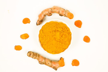 Turmeric powder and fresh turmeric on a white background