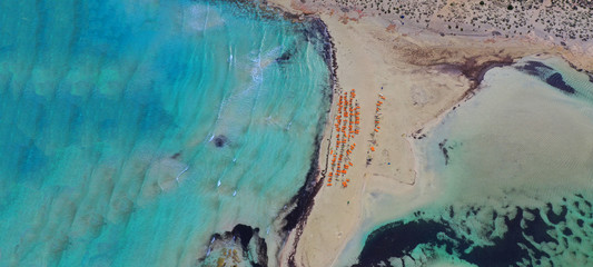 Aerial drone ultra wide photo of tropical exotic organised with sun beds sandy bay with turquoise sea