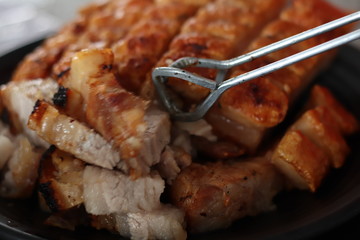 Assorted delicious grilled meat with beef stick and beef steak on black stove with smoke. grills some kind of marinated meat and vegetable on gas grill during summer party time. 