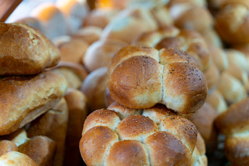 Assortment of baked bread on wooden table background in rustic bread bakery.