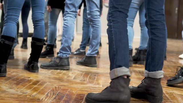 large group of children synchronously dance in blue jeans and black boots. training