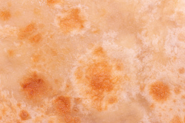 background texture chapatti, tortilla, fried in oil in a pan. top view, close up. home cooking concept